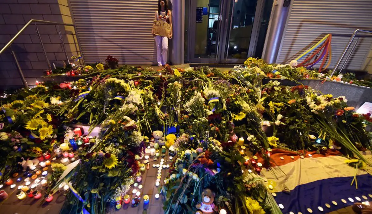 Ratusan karangan bunga dan lilin dinyalakan di depan Kedutaan Besar Belanda di Kiev, Ukraina, Jumat (17/7/14). (AFP PHOTO/Sergei Supinsky) 