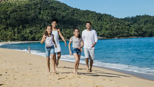 Sebuah keluarga kecil sedang berlarian di pantai (Foto Dok: Freepik/freepik)