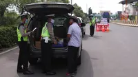 Petugas kepolisian melakukan pengecekan terhadap kendaraan yang keluar Tol Merak, Banten, Senin (18/5/2020). Pemeriksaan (check point) tersebut terkait larangan mudik guna penyekatan atau memeriksa kemungkinan pemudik yang akan keluar dari wilayah Jabodetabek. (Liputan6.com/Angga Yuniar)