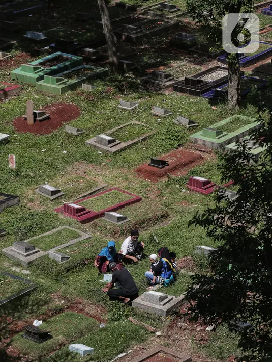 Warga berziarah kubur di makam keluarga pada hari kedua Lebaran di TPU Kebagusan, Jakarta, Senin (25/5/2020). Tradisi ziarah kubur saat Idul Fitri yang biasa dilakukan muslim relatif sepi dibandingkan tahun-tahun sebelumnya dikarenakan pandemi corona covid-19. (Liputan6.com/Johan Tallo)