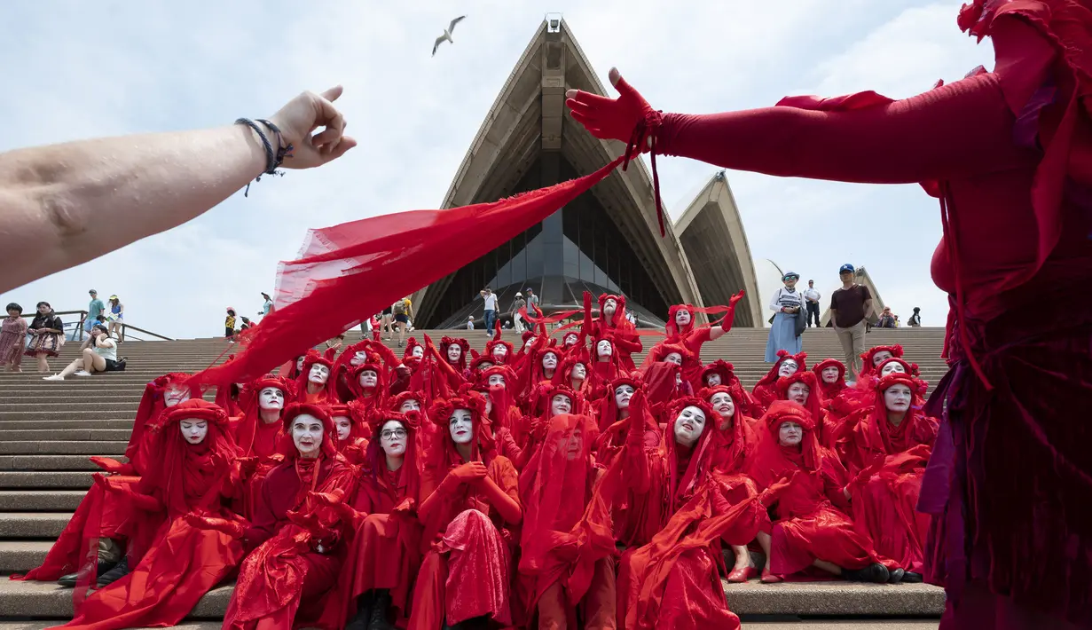 Aktivis yang terbagung dalam kelompok Red Rebels berunjuk rasa dalam demonstrasi protes iklim di Sydney (15/12/2019). Pengunjuk rasa melakukan aksi di depan landmark Gedung Opera Sydney menuntut pemerintah Australia menanggulangi asap yang menyebabkan masalah kesehatan. (AFP/Wendell Teodoro)