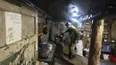 Seorang tentara Ukraina memasak di tempat penampungan dekat posisi pertempuran di garis pemisahan dari pemberontak pro-Rusia dekat Debaltsevo, wilayah Donetsk, Ukraina (3/12/2021). (AP Photo/Andriy Dubchak)