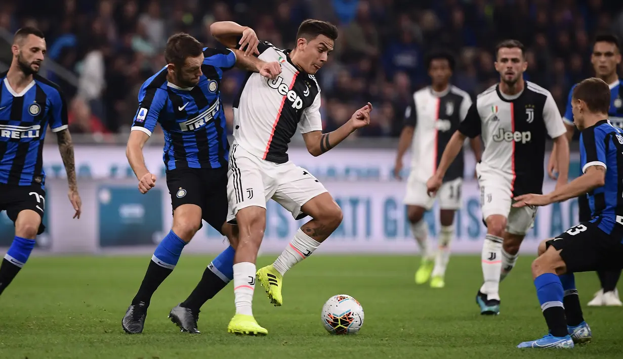 Penyerang Juventus Paulo Dybala berebut bola dengan bek Inter Milan, Stefan de Vrij dalam lanjutan kompetisi Serie A 2019-2020 di Stadion Giuseppe Meazza, Minggu (6/10/2019). Juventus memenangi duel bertajuk Derby d'Italia dengan keunggulan 2-1 atas Inter. (Marco Bertorello / AFP)