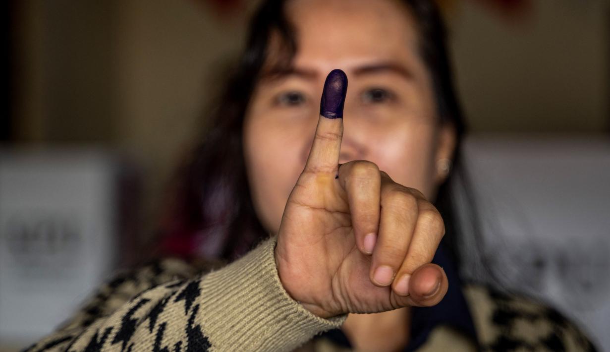 Pilkada 2024 diikuti oleh 1.556 pasangan kandidat kepala daerah di berbagai tingkat pemerintahan. Tampak dalam foto, pemilih menunjukkan jarinya yang bertinta setelah memberikan suaranya dalam pilkada serentak di Jakarta pada 27 November 2024. (BAY ISMOYO/AFP)