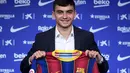 Penyerang Pedri berpose dengan jersey klub barunya Barcelona selama presentasi resmi di stadion Camp Nou di Barcelona (20/8/2020). Barcelona mengontrak Pedri dari Las Palmas. (AFP/Josep Lago)