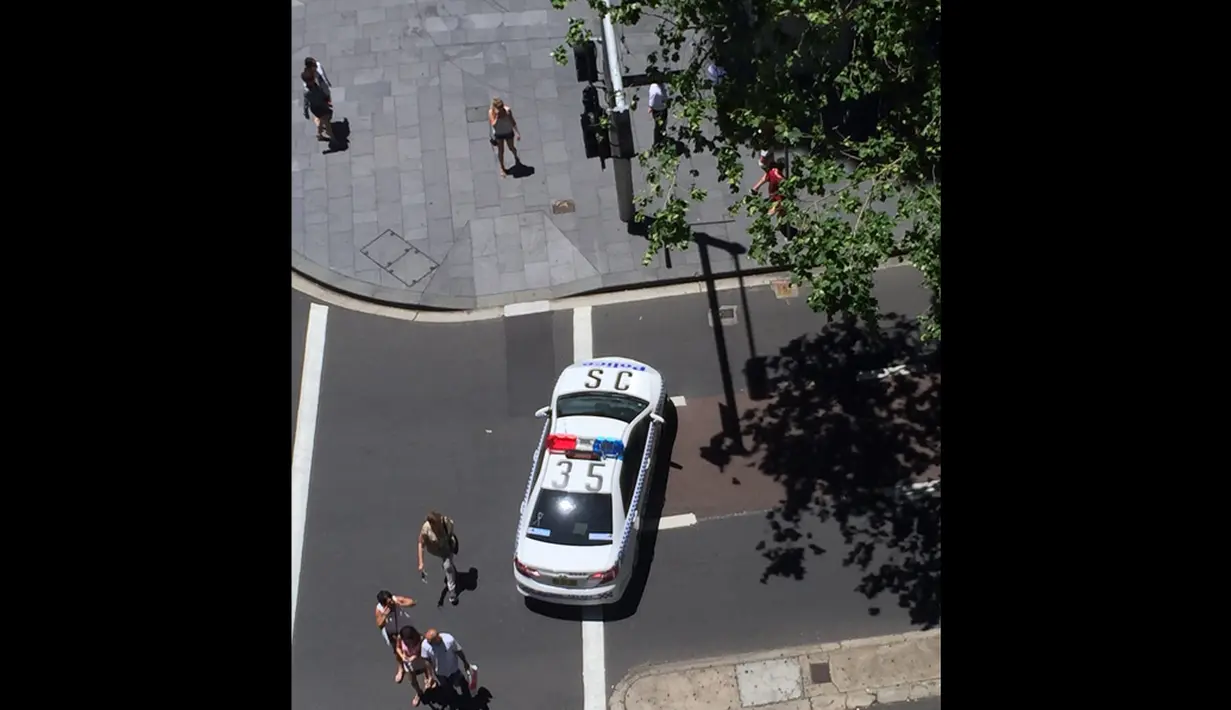 Sebuah mobil polisi menutup jalan di sekitar lokasi penyanderaan di The Lindt Chocolate Cafe, Sydney, Senin (15/12/2014). (Istimewa)