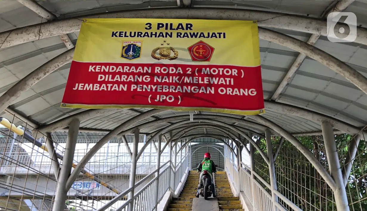Spanduk pemberitahuan terpasang di Jembatan Penyeberangan Orang (JPO) kawasan Pasar Minggu, Jakarta, Jumat (17/7/2020). Rendahnya kesadaran dalam disiplin berkendara menyebabkan sejumlah pengendara sepeda motor melintasi JPO tersebut meski merugikan pengguna lain. (Liputan6.com/Immanuel Antonius)