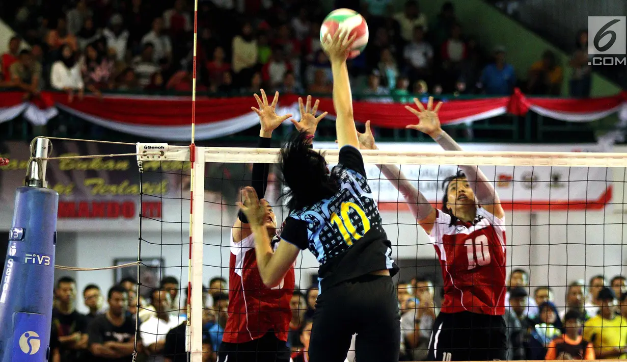 Tim Wahana Express Group (WEG) menahan bola pemain Voli AD (PBVAD) pada final turnamen Danjen Kopassus Open Volleyball Tournament, di GOR Nanggala, Minggu (08/4). WEG mengalahkan PB Voli AD (PBVAD) Putri, tiga set langsung. (Liputan6.com/Johan Tallo)