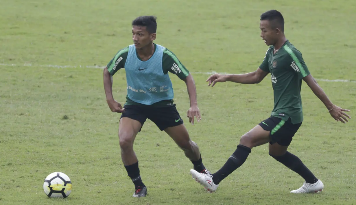 Pemain Timnas Indonesia U-23, T. M. Ichsan, berebut bola dengan Sani Rizki, saat latihan di Stadion Madya, Jakarta, Rabu (13/3). Latihan ini merupakan persiapan jelang Kualifikasi Piala AFC U-23. (Bola.com/Vitalis Yogi Trisna)