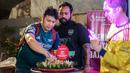 Ketua Arsenal Indonesia Supporters (AIS), Alif Sapto Nugroho (kiri) memotong nasi tumpeng untuk merayakan ulang tahun yang ke-21 AIS saat Roaring Night Liga Inggris antara Arsenal Vs Tottenham Hotspur di The Ground at Nipah, Jakarta Selatan, Minggu (28/04/2024). (Bola.com/Bagaskara Lazuardi)