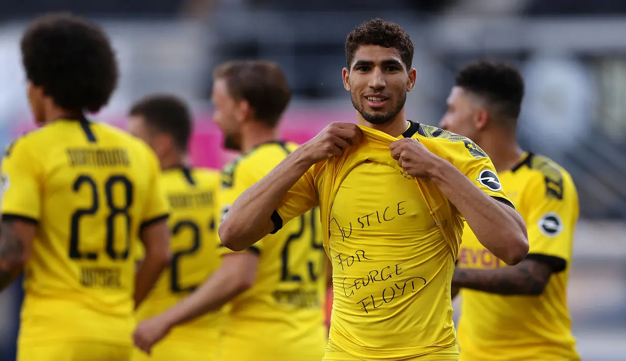 Gelandang Dortmund, Achraf Hakimi berselebrasi menunjukkan tulisan di kaos dalam 'Justice for George Floyd' usai mencetak gol ke gawang SC Paderborn 07 di Benteler Arena, Jerman (1/6/2020). George Floyd meninggal 25 Mei setelah ia dijepit di leher oleh polisi Minneapolis. (Lars Baron / Pool via AP)