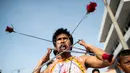 Penganut kuil Loem Hu Thai Su manusukkan batang besi panjang ke pipinya saat festival vegetarian tahunan di Phuket, Thailand, Jumat (12/10). Festival vegetarian ini sudah ada sejak tahun 1825. (Jewel Samad/AFP)