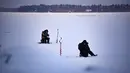 Dua orang pria memancing di tengah laut Bothnia yang sedang membeku di Vaasa, Finlandia, Rabu (27/12). Memancing di laut beku merupakan hal yang ditunggu-tunggu oleh sebagian warga setempat. (OLIVIER MORIN / AFP)