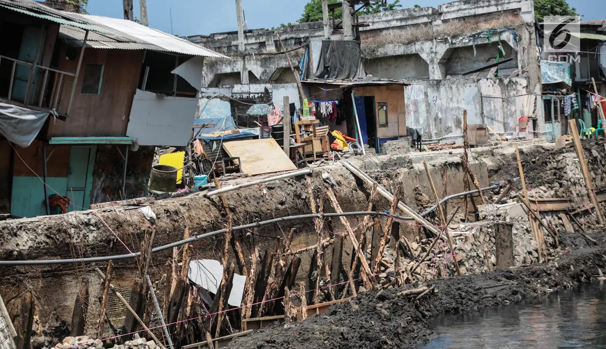 Sejumlah rumah hampir ambruk akibat amblesnya tanah di bantaran Anak Kali Ciliwung di Jalan Lodan Raya, Pademangan, Jakarta, Senin (19/11). Warga berharap pengerjaan penguatan dinding kali cepat selesai. (Liputan6.com/Faizal Fanani)