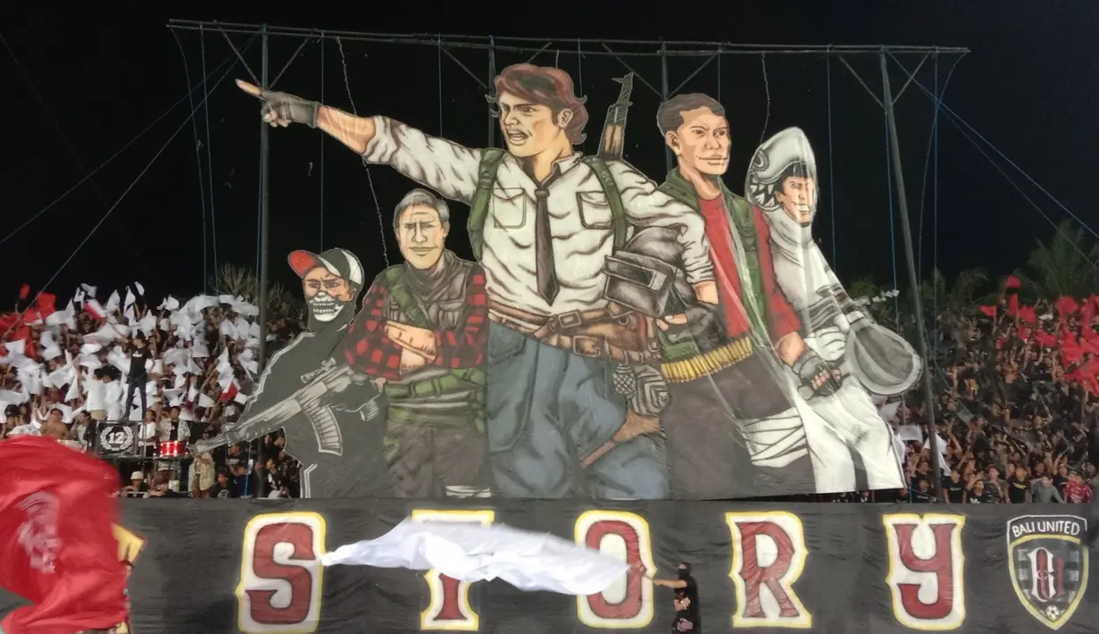 Suporter Bali United merayakan gelar juara Liga 1 2019 dengan menampilkan spanduk raksasa di Stadion Kapten I Wayan Dipta, Bali, Minggu (22/12). Bali berada di peringkat satu dengan meraih 64 poin. (Bola.com/Aditya Wany)