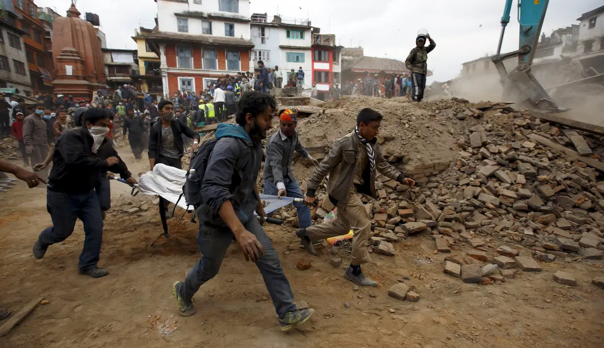 Sejumlah petugas segera melarikan warga yang terluka karena terkena runtuhan akibat gempa yang menghantam Nepal , Sabtu (25/4/2015). Dikabarkan sekitar 500 orang lebih tewas dalam peristiwa gempa tersebut (Reuters/Navesh Chitrakar)