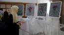 Seorang perempuan mengunjungi pameran seniman Palestina Kholoud al-Dasooqi di Gaza City, 11 Agustus 2020. Seniman Palestina asal Kota Khan Younis di Jalur Gaza itu menggelar pameran selama dua hari untuk mengungkap kekerasan terhadap perempuan melalui puluhan lukisan. (Xinhua/Rizek Abdeljawad)