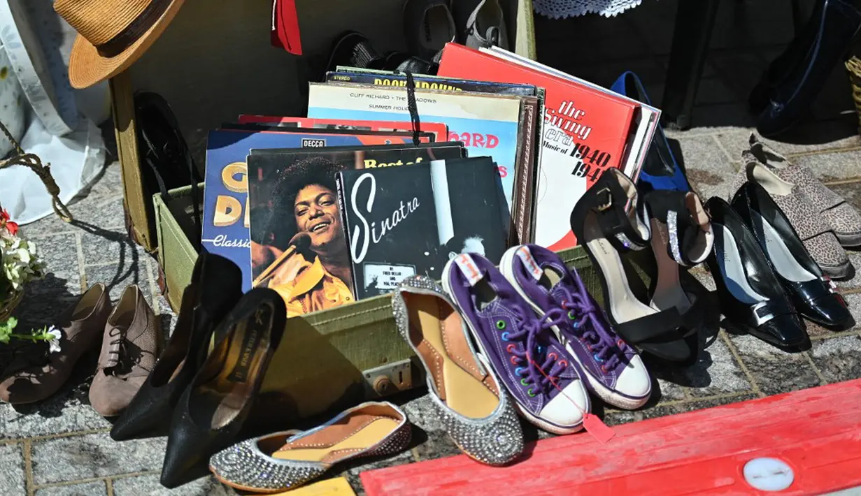 Catatan bekas, sepatu, dan barang-barang lainnya terlihat di sebuah kios di Classic Car Boot Sale, London, Inggris, 7 Agustus 2021. Classic Car Boot Sale berlangsung selama dua hari. (JUSTIN TALLIS/AFP)