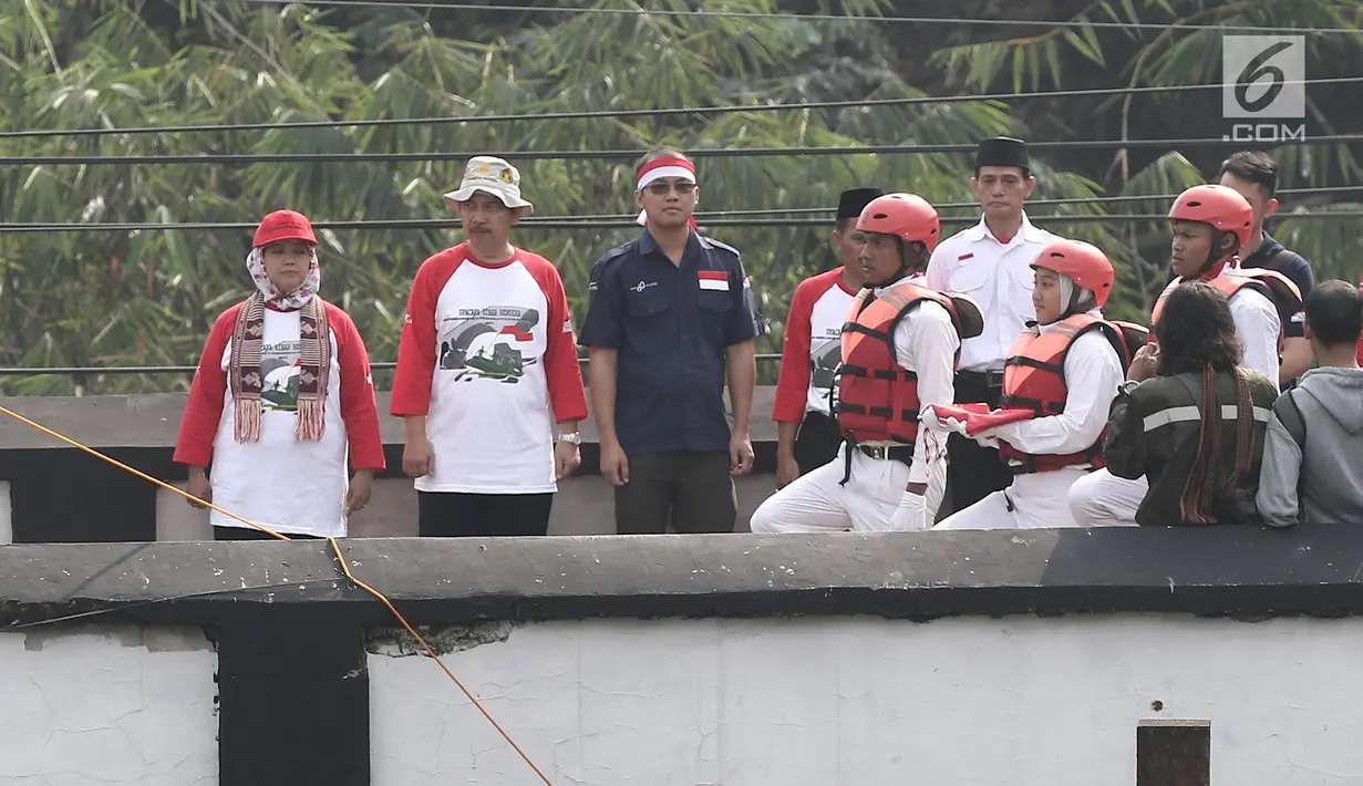 Pasukan Pengibar Bendera dalam upacara peringatan HUT Kemerdekaan RI di Jembatan Panus, Depok, Kamis (17/8). Komunitas Ciliwung Depok mengibarkan bendera Merah Putih di Jembatan Panus yang melintang di atas Sungai Ciliwung. (Liputan6.com/Herman Zakharia)