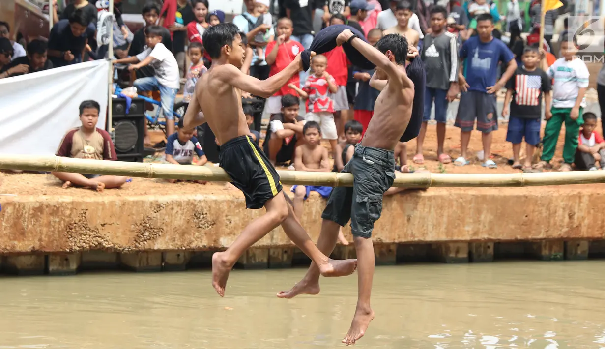 Anak-anak bermain lomba pukul bantal di sekitar Kalimalang, Jakarta, Sabtu (17/8/2019). Beragam lomba permainan digelar warga untuk menyemarakkan HUT ke-74 Republik Indonesia. (Liputan6.com/Helmi Fithriansyah)