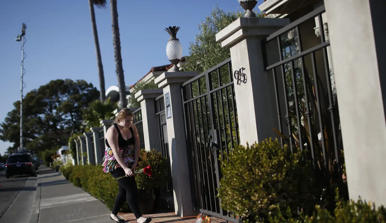 Seorang fans meletakkan karangan bunga di depan rumah Robin Williams, California, Senin (11/8/14). (REUTERS/Stephen Lam)