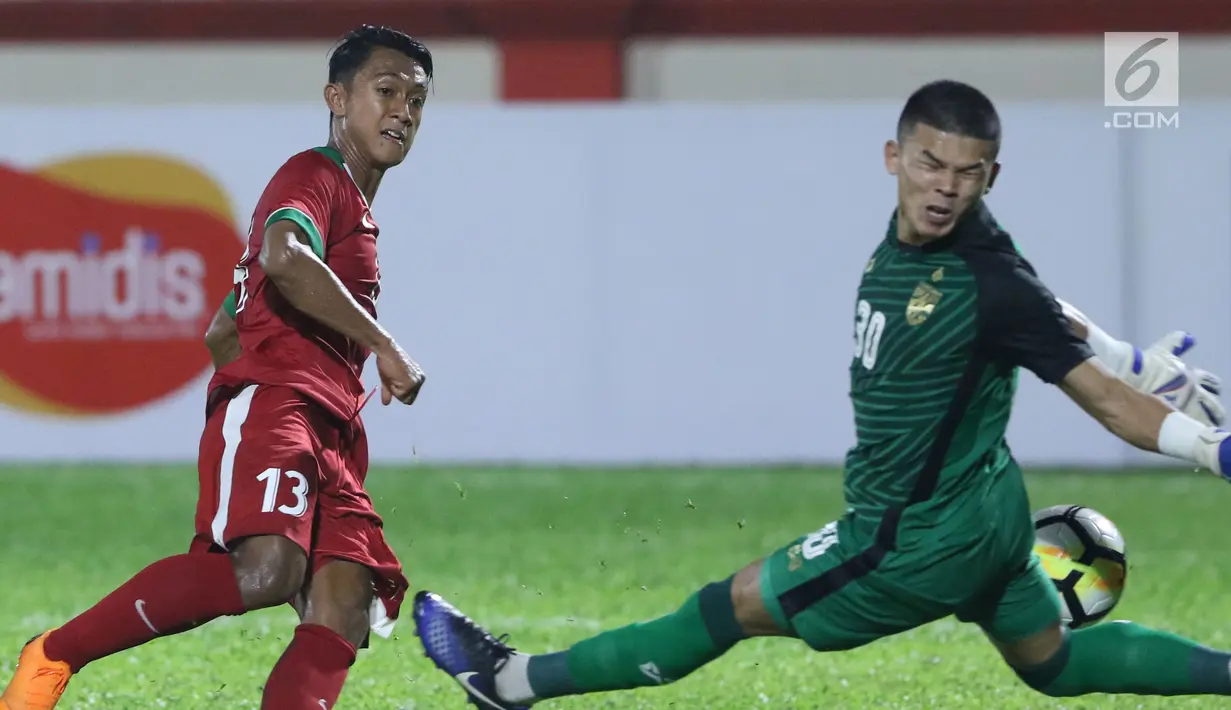 Pemain sayap Timnas Indonesia U-23, Febri Hariyadi (kiri) mencoba mengecoh kiper Thailand U-23, Kwanchai Suklom pada laga persahabatan di Stadion PTIK, Jakarta, Kamis (31/5). Indonesia U-23 kalah 1-2. (Liputan6.com/Helmi Fithriansyah)