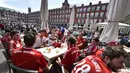 Para suporter Bayern Muenchen berkumpul di teras bar di Plaza Mayor sebelum pertandingan leg kedua perempat final Liga Champions antara Real Madrid dan Bayern Muenchen di stadion Santiago Bernabeu, Spanyol (18/4). (AFP Photo / Gerard Julien)