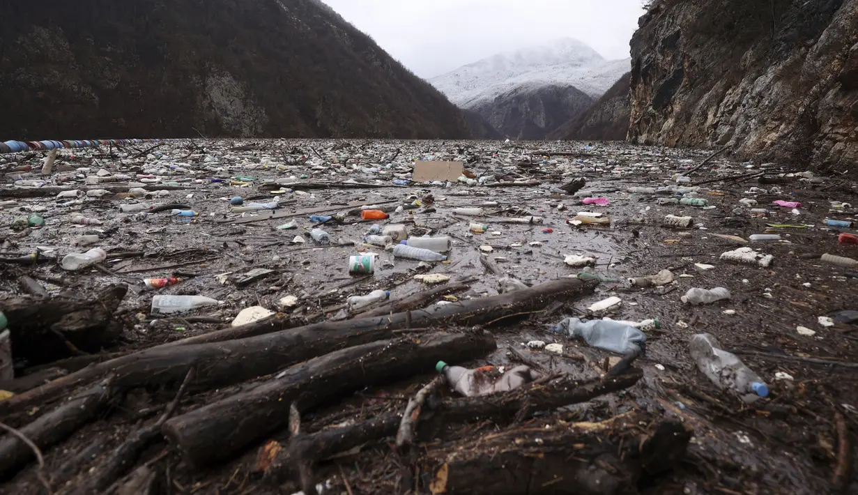 Sampah mengambang di sungai Drina dekat Visegrad, Bosnia, Jumat, 20 Januari 2023. Berton-ton limbah yang dibuang di tempat pembuangan sampah tepi sungai yang tidak diatur dengan baik atau langsung ke sungai-sungai di tiga negara Balkan Barat akhirnya menumpuk selama musim air tinggi di musim dingin dan musim semi, di belakang penghalang sampah di Sungai Drina, Bosnia timur. (AP Photo/Armin Durgut)