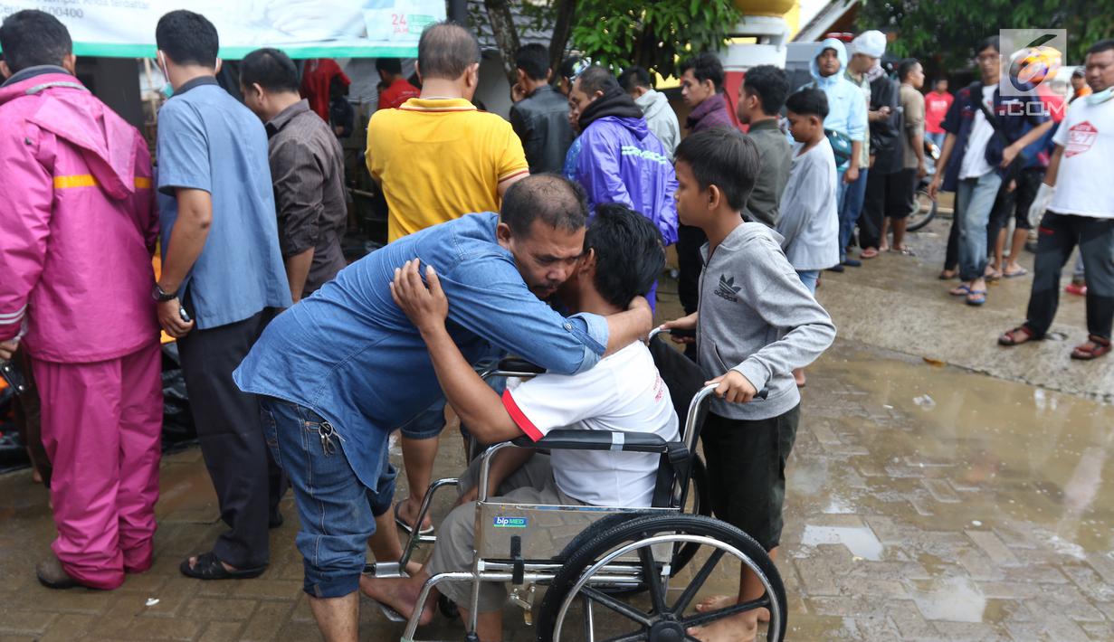 Keluarga korban berpelukan ketika berusaha mencari keluarga mereka yang meninggal akibat gelombang Tsunami Anyer di Puskesmas Carita, Banten, Minggu (23/12). BNPB dan pemerintah daerah masih melakukan tanggap bencana darurat. (Liputan6.com/Angga Yuniar)