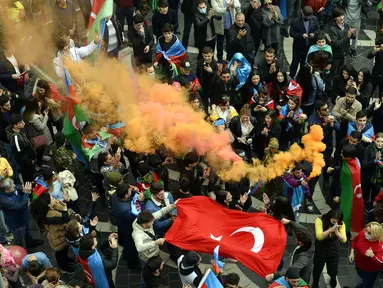 Rakyat Azerbaijan mengibarkan bendera nasional dan Turki di Baku, Azerbaijan, Selasa (10/11/2020). Armenia dan Azerbaijan mengumumkan perjanjian damai untuk menghentikan pertempuran atas wilayah Nagorno-Karabakh di Azerbaijan berdasarkan pakta yang ditandatangani dengan Rusia. (AP Photo)