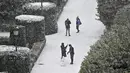Orang-orang membuat manusia salju di Taman Sabatini di luar Istana Kerajaan, Madrid, Spanyol, Jumat (8/1/2021). Badai Filomena mengakibatkan salju lebat turun di Madrid dan seluruh Spanyol. (GABRIEL BOUYS/AFP)