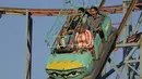 Warga Irak menikmati wahana jet coaster di sebuah taman hiburan saat Idul Adha di Baghdad, Irak, Kamis, 29 Juni 2023. (AP Photo/Hadi Mizban)