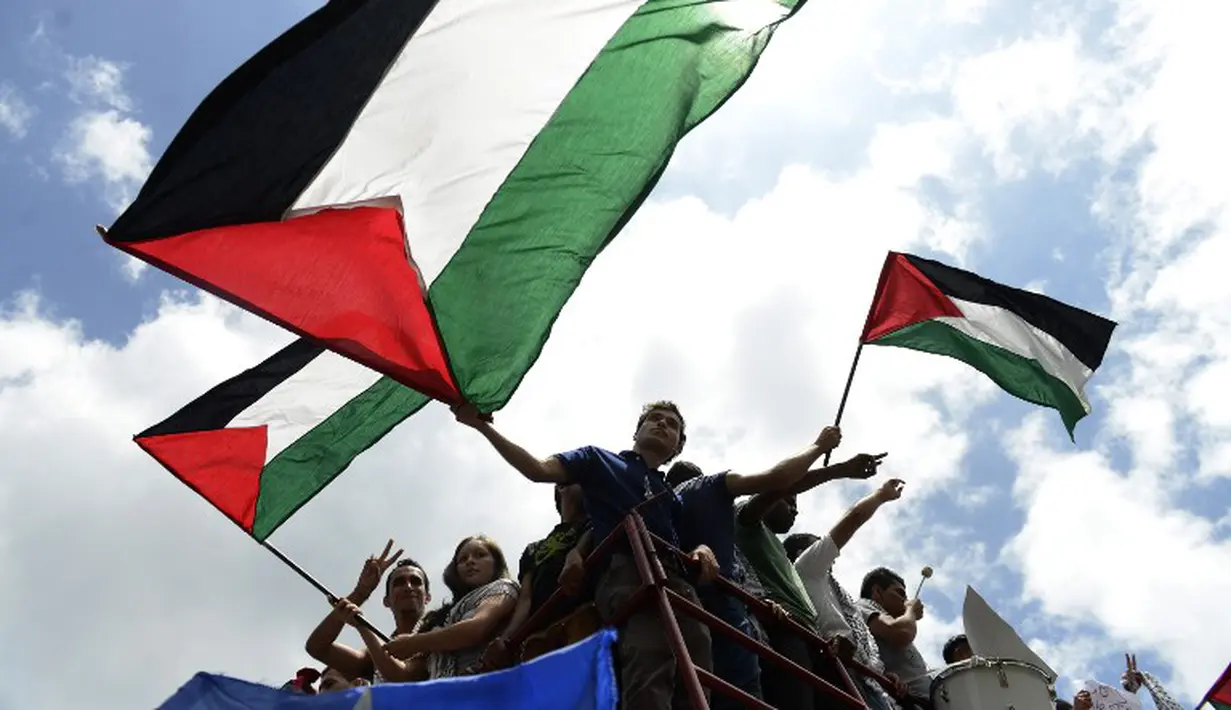 Pengunjuk rasa Venezuela melakukan aksi simpatik. Mereka menuntut PBB untuk segera turun tangan menciptakan perdamaian Palestina di depan Kedutaan Besar Palestina di Caracas (14/7/2014) (AFP PHOTO / Leo RAMIREZ)