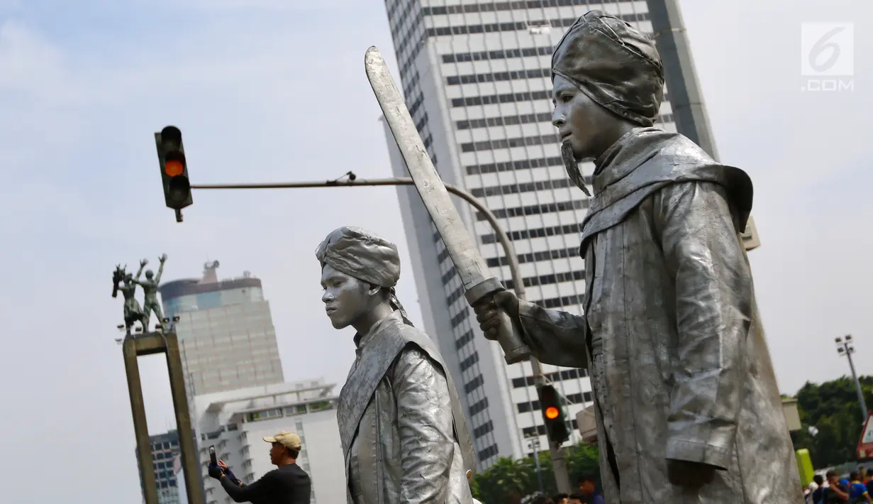 Dua seniman yang berperan Pangeran Diponegoro dan Imam Bonjol berdiri saat kegiatan Car Free Day di Bundaran HI di Jakarta, Minggu, (12/11). Untuk dapat berswafoto warga dikenakan tarif semampunya. (Liputan6.com/Fery Pradolo)