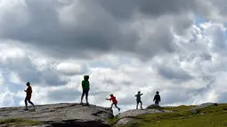 Anak-anak berjalan ke Haytor Rocks di Taman Nasional Dartmoor, dekat Exeter, Inggris barat daya, (12/8/2019). Titik tertinggi di kawasan ini adalah High Willhays, 621 m (2037 ft) di atas permukaan laut. (AFP Photo/Ben Stansall)