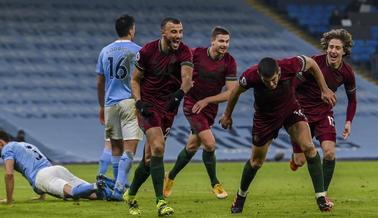 Para pemain Wolverhampton Wanderers merayakan gol penyeimbang 1-1 yang dicetak bek Conor Coady ke gawang Manchester City dalam laga lanjutan Liga Inggris 2020/21 pekan ke-27 di Etihad Stadium, Selasa (2/3/2021). Wolverhampton kalah 1-4 dari Manchester City. (AP/Paul Ellis/Pool)