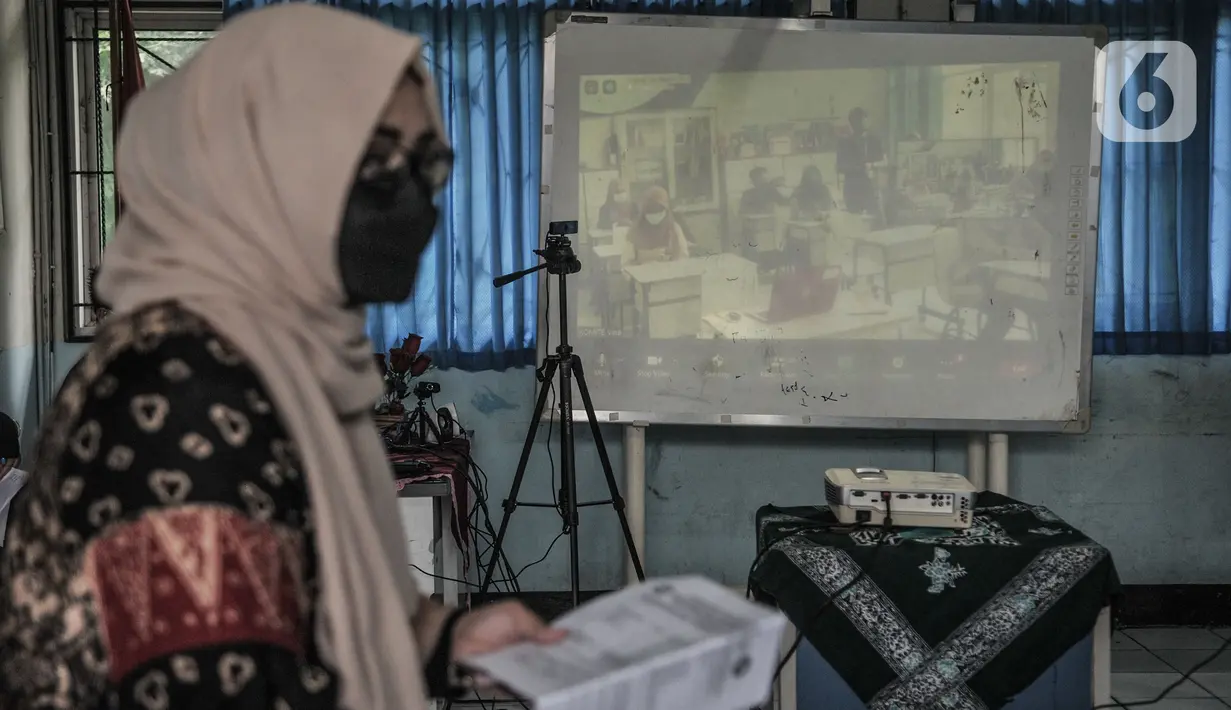 Suasana saat simulasi sekolah dengan model Kelas Hybrid di SMPN 255, Jakarta, Selasa (30/3/2021). Kelas Hybrid merupakan model sekolah tatap muka secara rotasi dengan jumlah kehadiran siswa 50 persen dengan kombinasi pembelajaran antara teknik pengajaran dan teknologi. (merdeka.com/Iqbal S Nugroho)