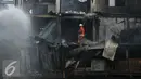 Petugas pemadam kebakaran memadamkan api yang membakar pemukiman di kawasan padat penduduk Bukit Duri, Jakarta, Selasa (23/2). Hingga kini penyebab kebakaran masih dalam penyelidikan pihak terkait. (Liputan6.com/Gempur M Surya)