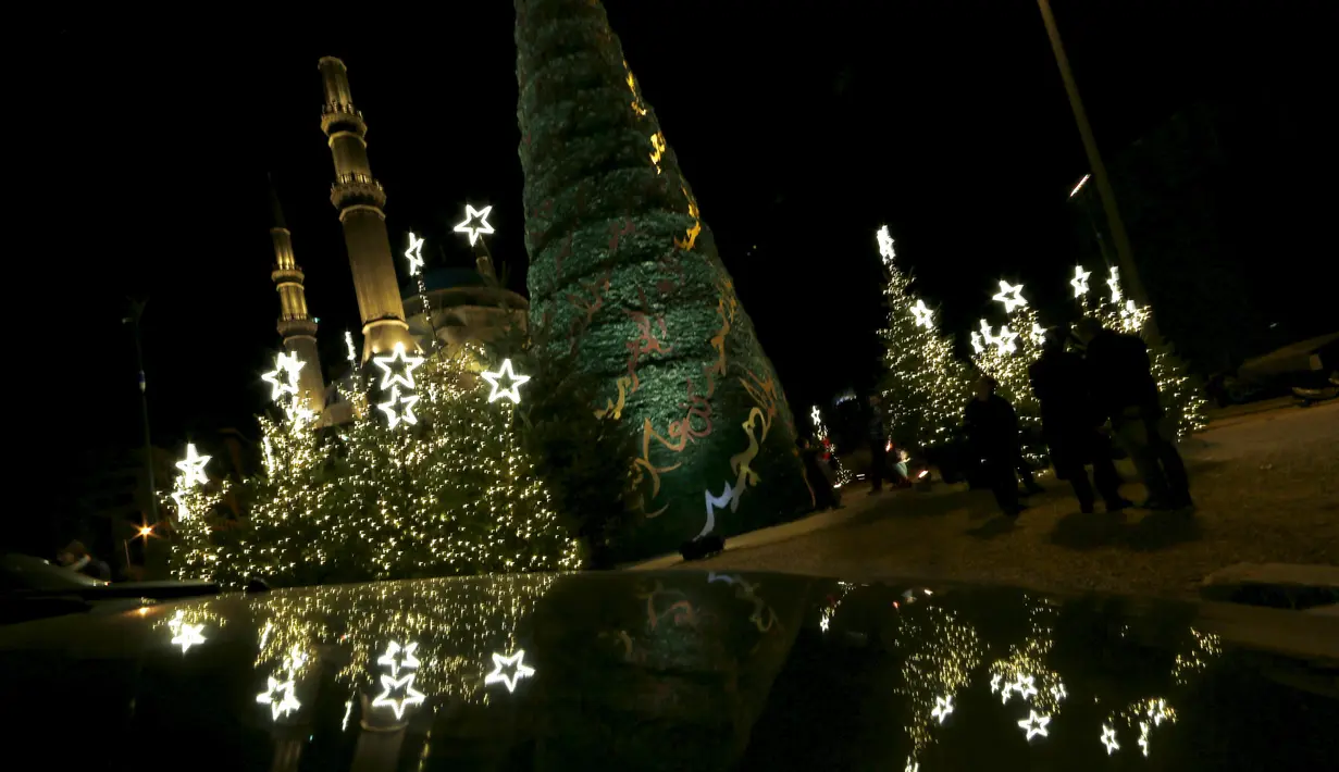 Sebuah pohon Natal raksasa yang dirancang oleh desainer Lebanon, Elie Saab terlihat berdiri di depan Masjid Al-Amin, di pusat kota Beirut, 12 Desember 2015. (REUTERS/Jamal Saidi)