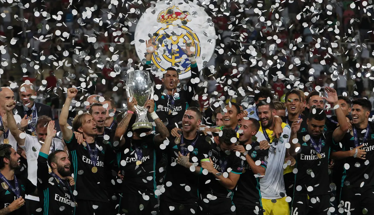 Pemain Real Madrid mengangkat trofi Piala Super Eropa usai menumbangkan Manchester United (MU) 2-1 di Skopje, Macedonia, Selasa (8/8). Ini merupakan gelar Piala Super Eropa keempat bagi Real Madrid. (AP Photo/Boris Grdanoski)