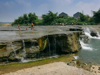 Suasana aliran sungai Gunung Sari, Desa Tajur, Pasirmukti, Citeureup, Bogor, Jawa Barat (24/6/2019). Liburan anak sekolah banyak dimanfaatkan bagi masyarakat disekitar Citeureup dan Cibinong untuk berwisata. (Kapanlagi.com/Budy Santoso)