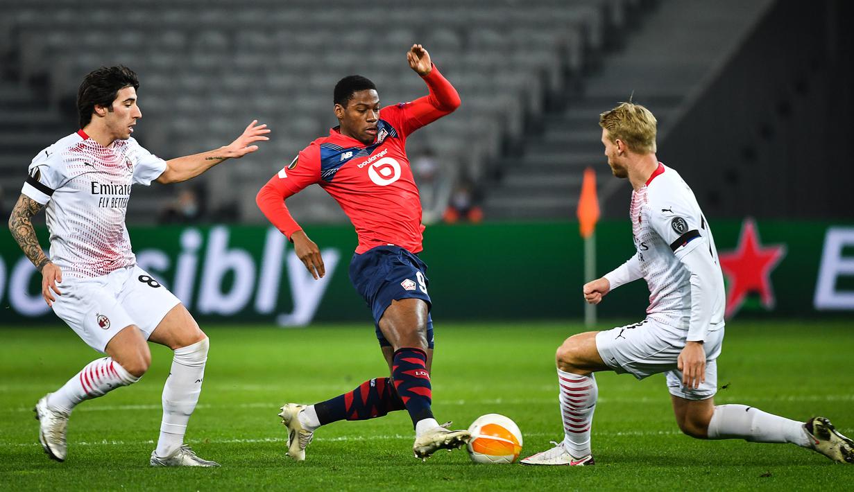 Gelandang AC Milan, Sandro Tonali, berebut bola dengan penyerang Lille, Jonathan David, pada laga lanjutan Liga Europa di Stade Pierre Mauroy, Jumat (27/11/2020) dini hari WIB. AC Milan bermain imbang 1-1 menghadapi Lille. (AFP/Dennis Charlet/pool)