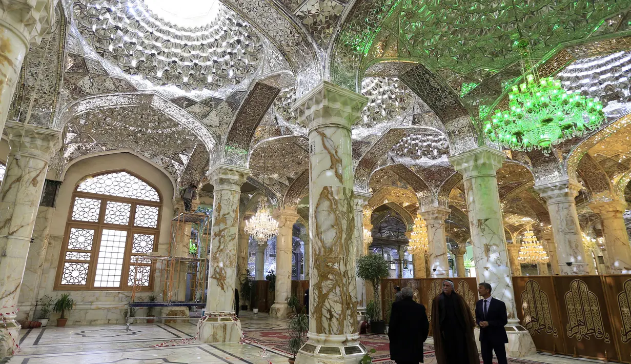 Jemaah berada di dalam bangunan masjid makam Imam Ali di kota Najaf, Irak (23/1). Masjid ini selesai dibangun pertama kali pada tahun 977. (AFP Photo/Haidar Hamdani)