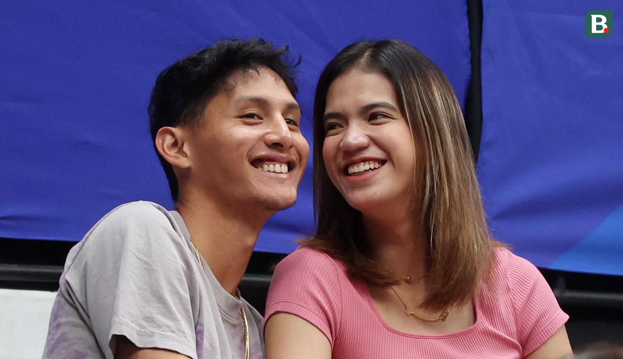 Atlet basket, Daniel Wenas, bersama pevoli putri, Shella Bernadetha, tampak tersenyum saat menonton langsung pertandingan FIBA World Cup 2023 antara Prancis vs Pantai Gading di Indonesia Arena, Sabtu (2/9/2023). (Bola.com/M Iqbal Ichsan)