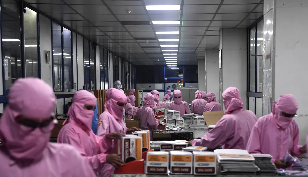 Para pekerja mengemas jarum suntik di pabrik Jarum Suntik Hindustan di Faridabad (2/9/2020). Produsen jarum suntik terbesar di India meningkatkan produksinya untuk menghasilkan satu miliar unit. (AFP/Sajjad Hussain)