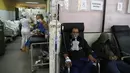 Pasien COVID-19 duduk di kursi dan tempat tidur di lorong pintu masuk Rumah Sakit Umum di Luque, Paraguay, Jumat (11/6/2021). Menurut Kementerian Kesehatan Paraguay, negara itu telah melampaui 10.000 kematian terkait COVID -19 minggu ini. (AP Photo/Jorge Saenz)