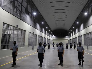 Penjaga sipil dari Direktorat Jenderal Penjara berdiri di luar sel tahanan saat tur media di Pusat Pengurungan Terorisme, Tecoluca, El Salvador, 2 Februari 2023. Menurut pemerintah, penjara besar yang masih dalam pembangunan tersebut memiliki kapasitas maksimum 40.000 narapidana dan dimaksudkan untuk memenjarakan anggota geng. (AP Photo/Salvador Melendez)