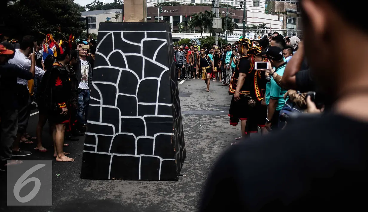 Seorang pria bersiap berlari untuk melakukan lompat batu dalam sebuah acara pagelaran seni dan kebudayaan Nias di Jalan Imam Bonjol, Jakarta, Minggu (12/2). (Liputan6.com/Faizal Fanani)