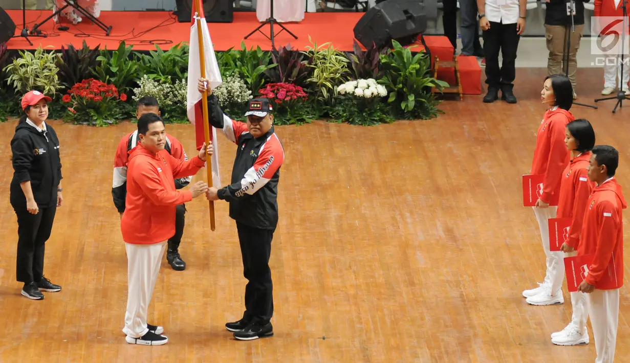 Ketua KOI, Erick Thohir (kedua kiri) menyerahkan bendera Merah Putih kepada Ketua Kontingen Indonesia untuk Asian Games 2018, Komjen Pol Syafruddin saat upacara pengukuhan di Istora Senayan, Jakarta, Minggu (5/8). (Liputan6.com/Helmi Fithriansyah)