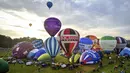 Sejumlah balon bersiap lepas landas massal dalam festival tahunan balon udara panas Bristol di Bristol, Inggris (8/8/2019). Festival balon udara ini diadakan selama empat hari dari 8-11 Agustus 2019. (Ben Birchall/PA via AP)